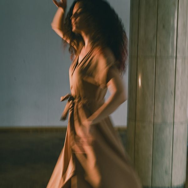 Woman performing a fluid yoga movement, symbolizing the flow of energy.